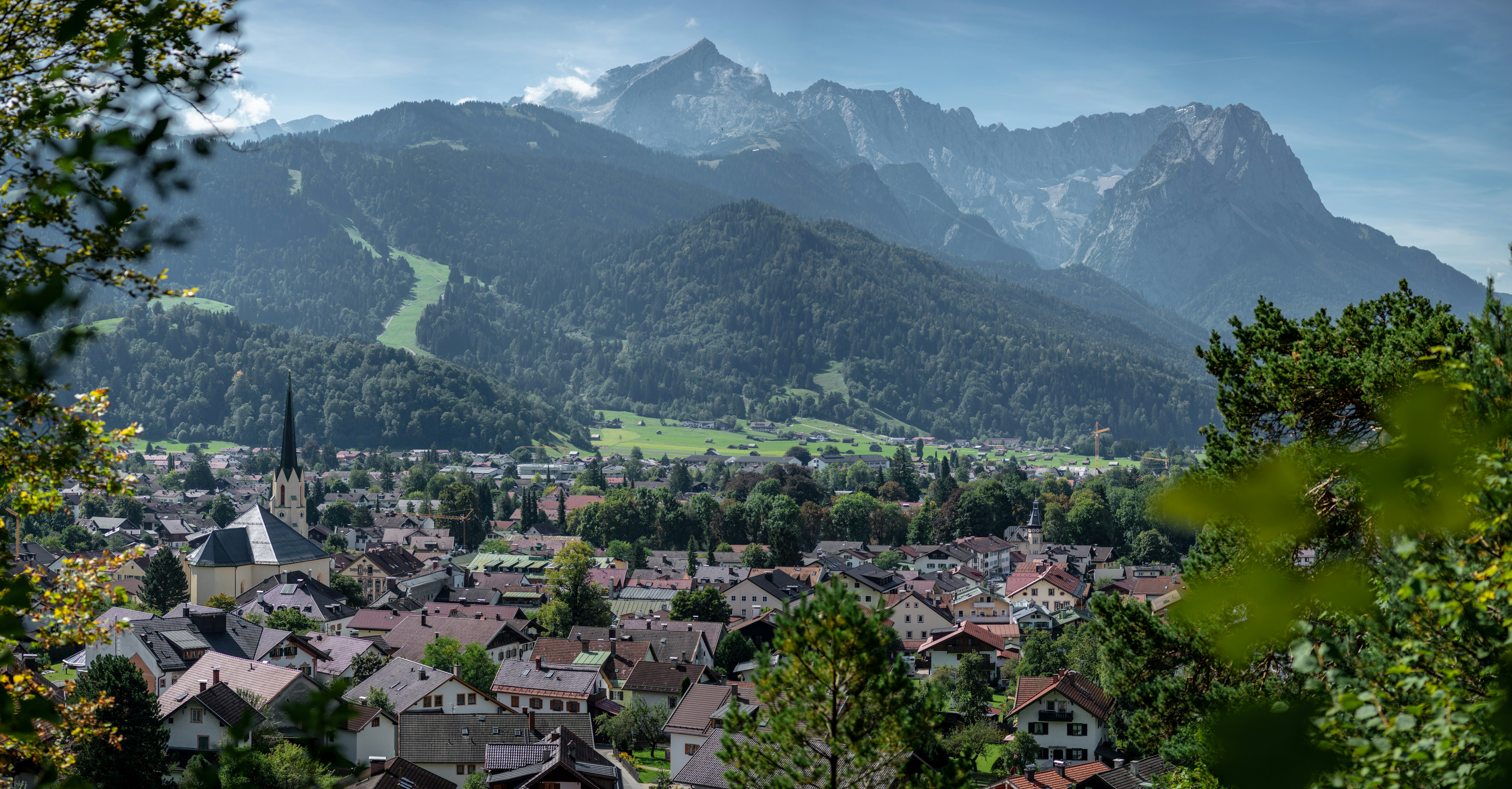 aerial view of city near green mountains during daytime